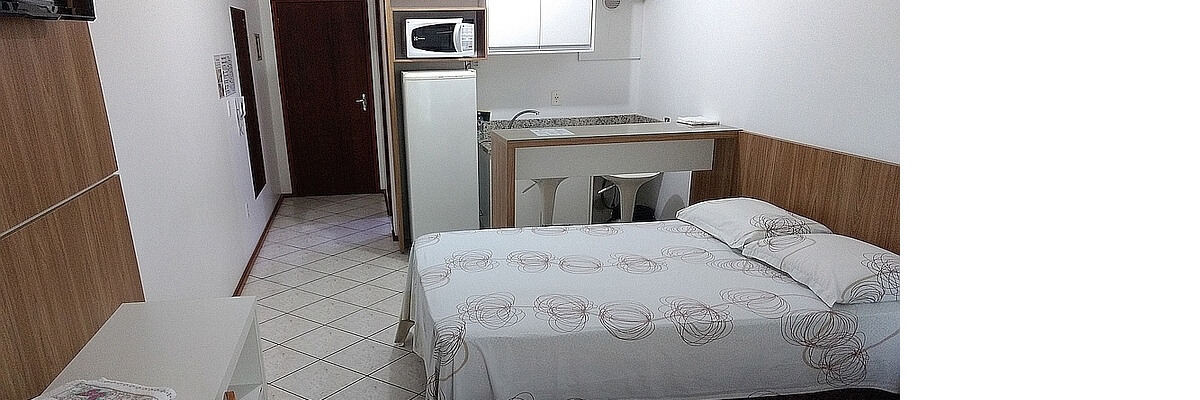 Flat's internal area showing the bed and the kitchen